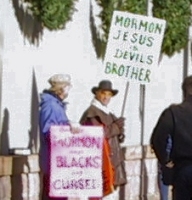 Mormon protestors - 'Mormon Jesus is Devil's brother' and 'Mormons say Blacks are Cursed'